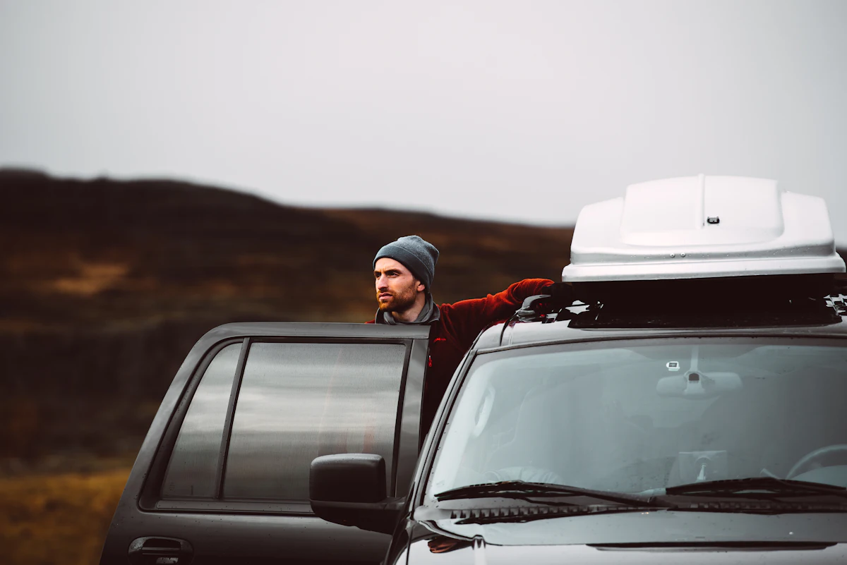 Auto se střešním boxem na road tripu otevřenou krajinou